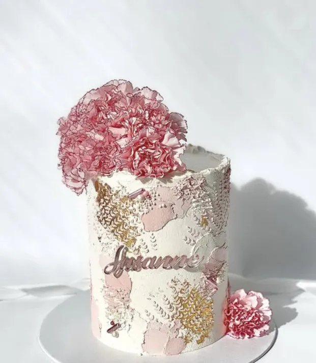 Hvit og rosa kake med nellik på toppen